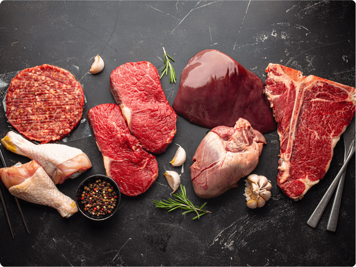An assortment of butchered meat on a black, marble table for Portabulls cold storage units used by butchers (2) (1)